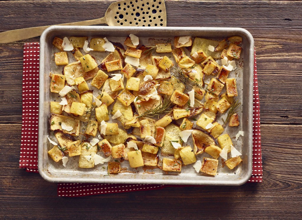 Roasted Rind Parmesan in baking pan with spatula on side. Set on red with white polkadot napkin on wooden table