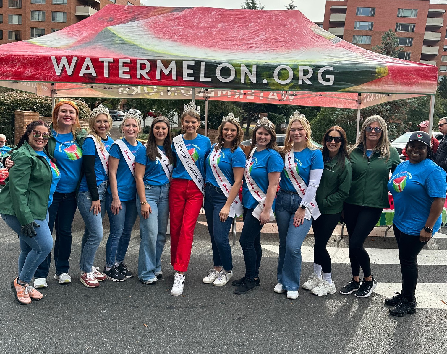 Group photo of watermelon queens and NWPB staff in front of Watermelon.org tent at the 2024 Marine Corps Marathon